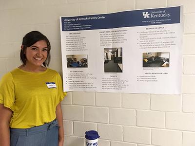 Internship Spotlight: Kirstie Otto stands beside a poster presentation