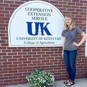 Internship Spotlight: Rachel Hart stands beside a UK Cooperative Extension Service sign